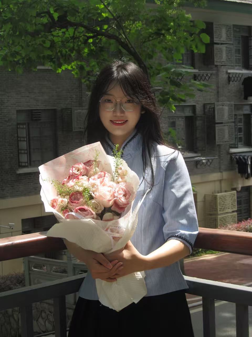 Xinyi Zhang holding a bouquet on campus