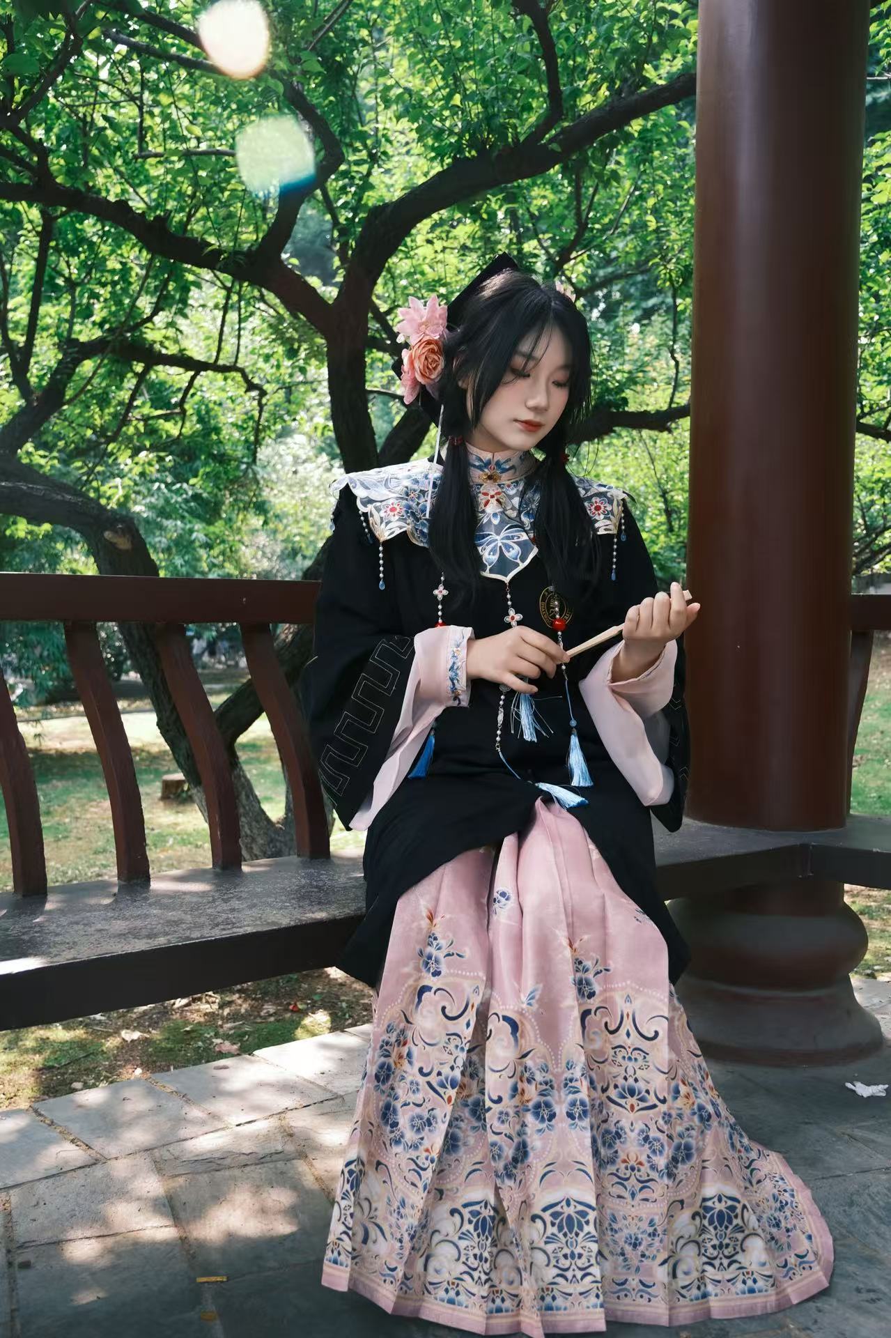 Xinyi Zhang in traditional dress in a garden pavilion
