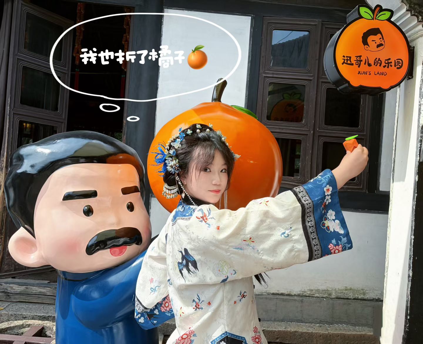Xinyi Zhang in traditional dress beside a playful orange display